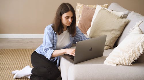 Woman Sitting On The Floor While Using Her Laptop
