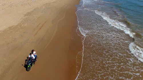 People On A Motorbike Driving Along The Seashore