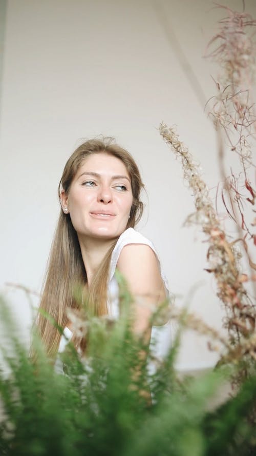 Woman Standing Behind Flowering Plants