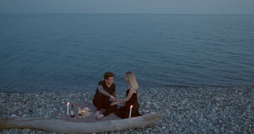 Couple Kissing Each Other and Having a Dinner Date on Rocky Shore