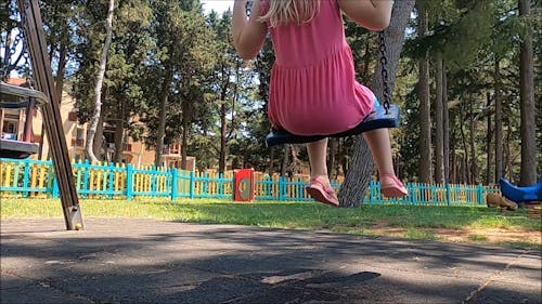 Young Girl Playing on a Swing at the Playground