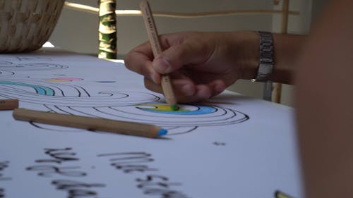 Man Coloring An Illustration