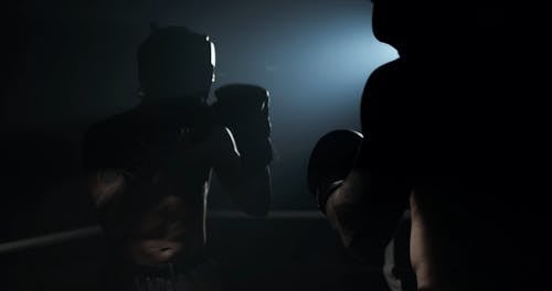 Two Men Sparring In A Boxing Match Under A Stroboscope