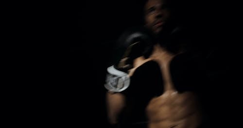 A Boxer Stepping In The Spot Light Throwing Punches