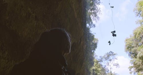 A Woman Standing Near And Below  Waterfall