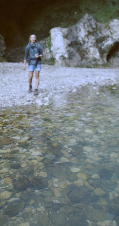 A Young Woman Throwing A Rock On The River