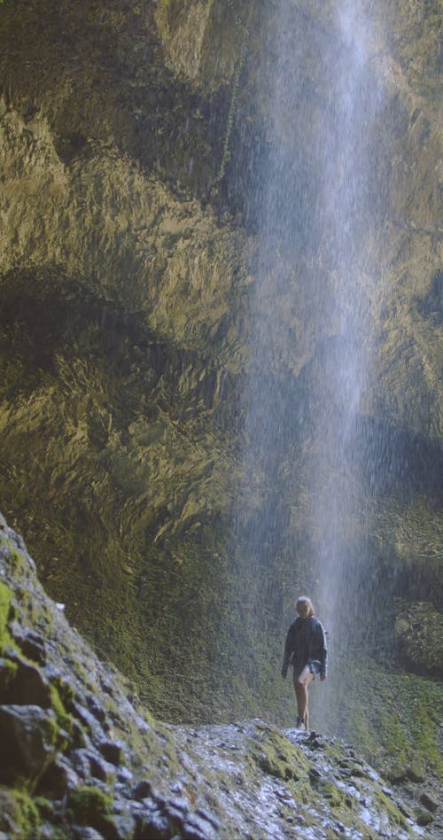 Woman Walking Under the Water Falls