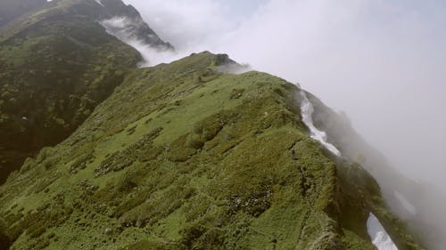 People Climbing The Mountains On A Foggy Day