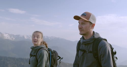 A Couple Chatting While Hiking a Mountain