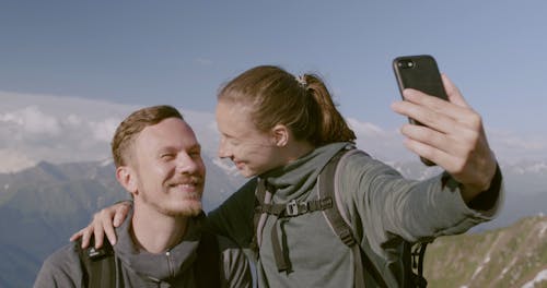 A Couple Taking Selfie Photo At The Mountain Peak