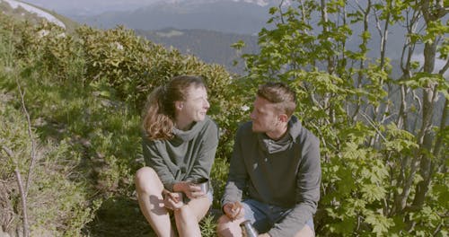 A Couple Having Snack While Resting n The Mountain Trail