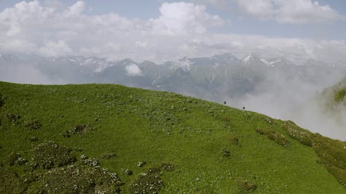 A Couple Trekking a Mountain Trail To Reach The Top