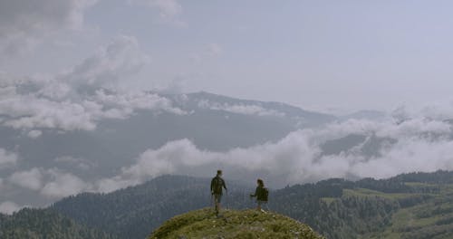 A Couple Reaching The Mountain Summit