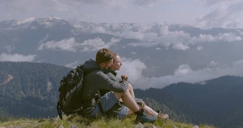 A Couple Enjoying The Scenic View Atop A Mountain