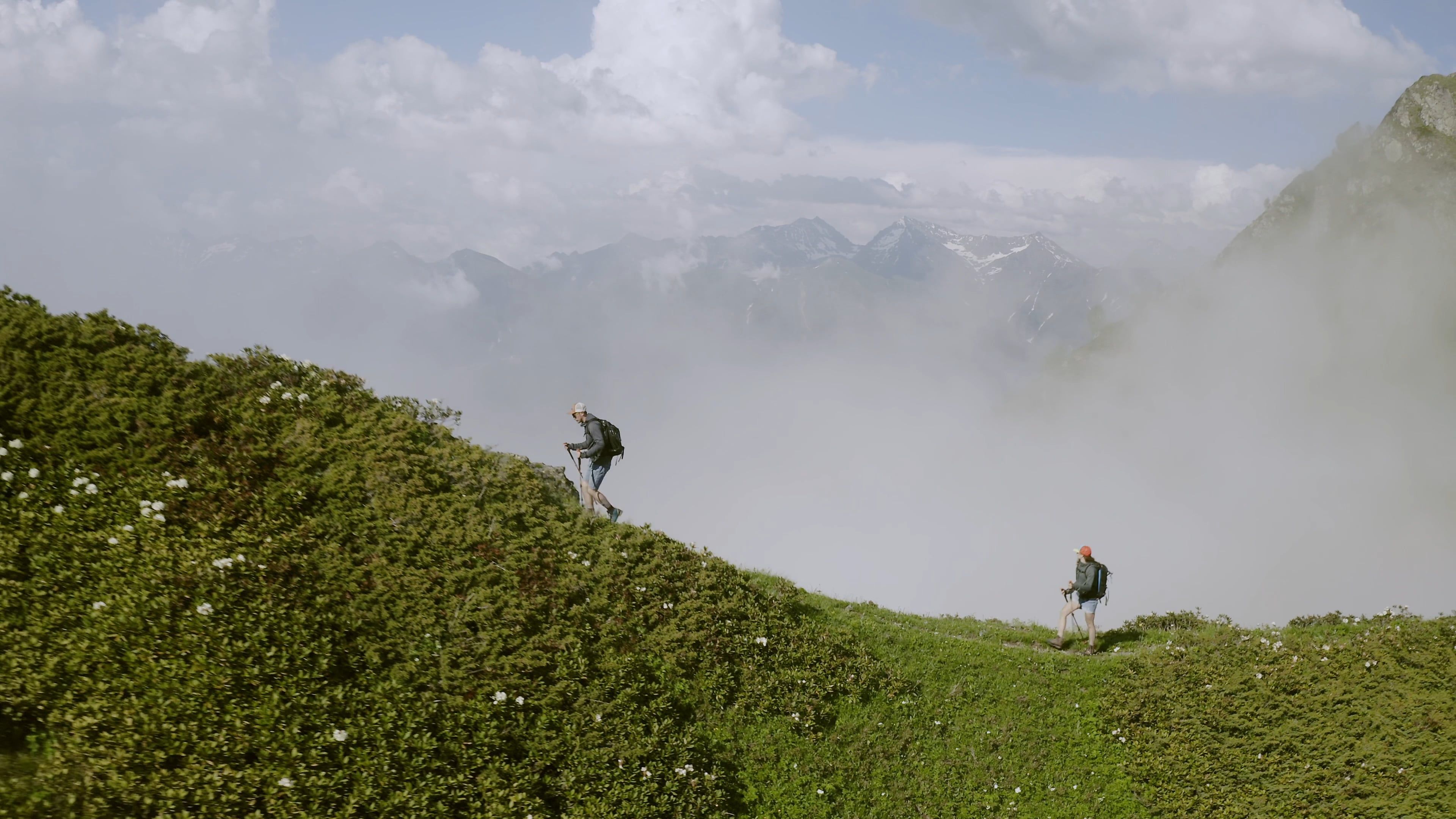 A hiker on a mountain ridge above the clouds