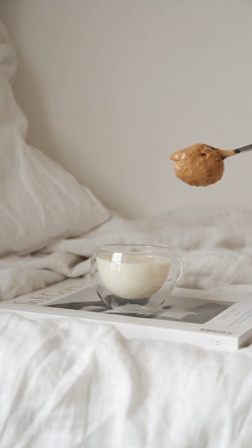 Person Placing Coffee On A Glass Of Milk