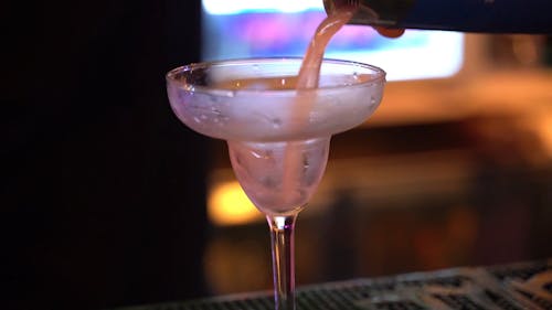 Pouring Alcoholic Drink On A Cocktail Glass