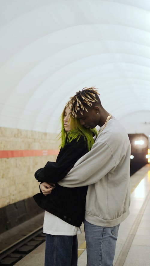 A Couple In A Bear Hug While Waiting In The Subway Platform