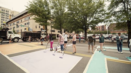 People Painting The Street With Mural