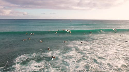 Surfers Riding The Big Waves Of The Sea