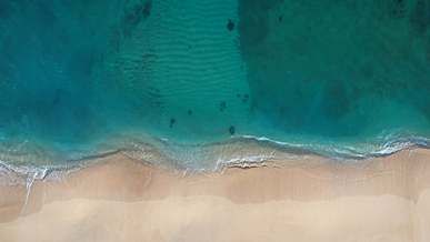 sea waves crashing the white sand of the beach