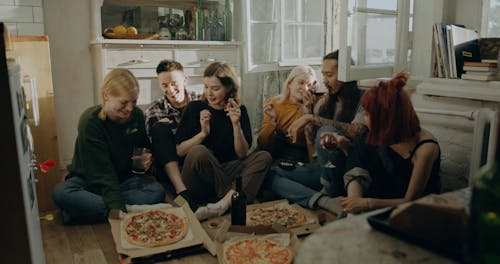 People Sitting on Floor While Drinking and Eating