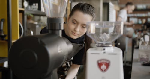 Ein Weiblicher Barista, Der Die Frischen Gemahlenen Kaffeebohnen Riecht