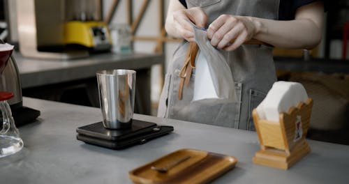 Pouring And Weighing Fresh Coffee Bean Over A Tin Cup 