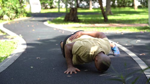Shallow Focus of Man in Yellow Shirt Doing One-Arm Push-Ups