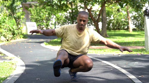 Man in Yellow Shirt Balancing With His Left Foot