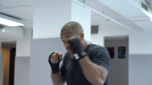 Shallow Focus of Man in Black Shirt Punching