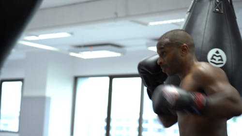 A Man Hitting A Punching Bag With Force