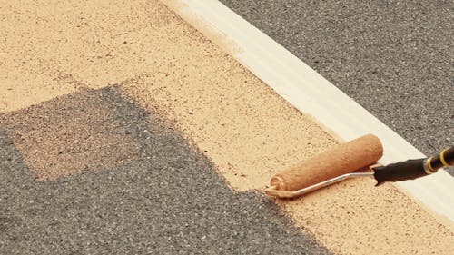 Street Rulo Paint Person Painting the Street With a Mural · Free Stock Video