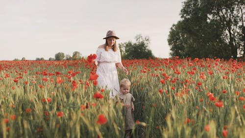 Mom and Daughter Walking on Red Poppy Flower Field