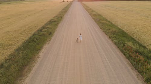 Drone Footage Of Mother And Child Walking On Dirt Road 