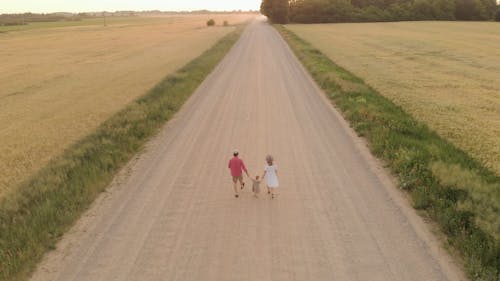 Drone Footage Of Family Walking On Dirt Road