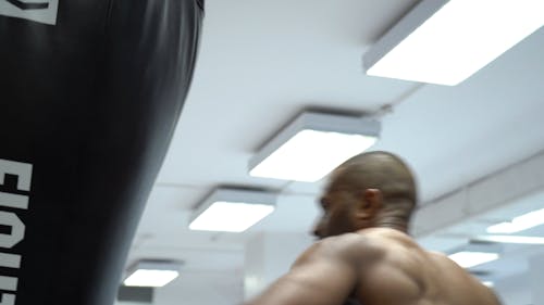 A Man Striking A Heavy Bag With His Elbows 