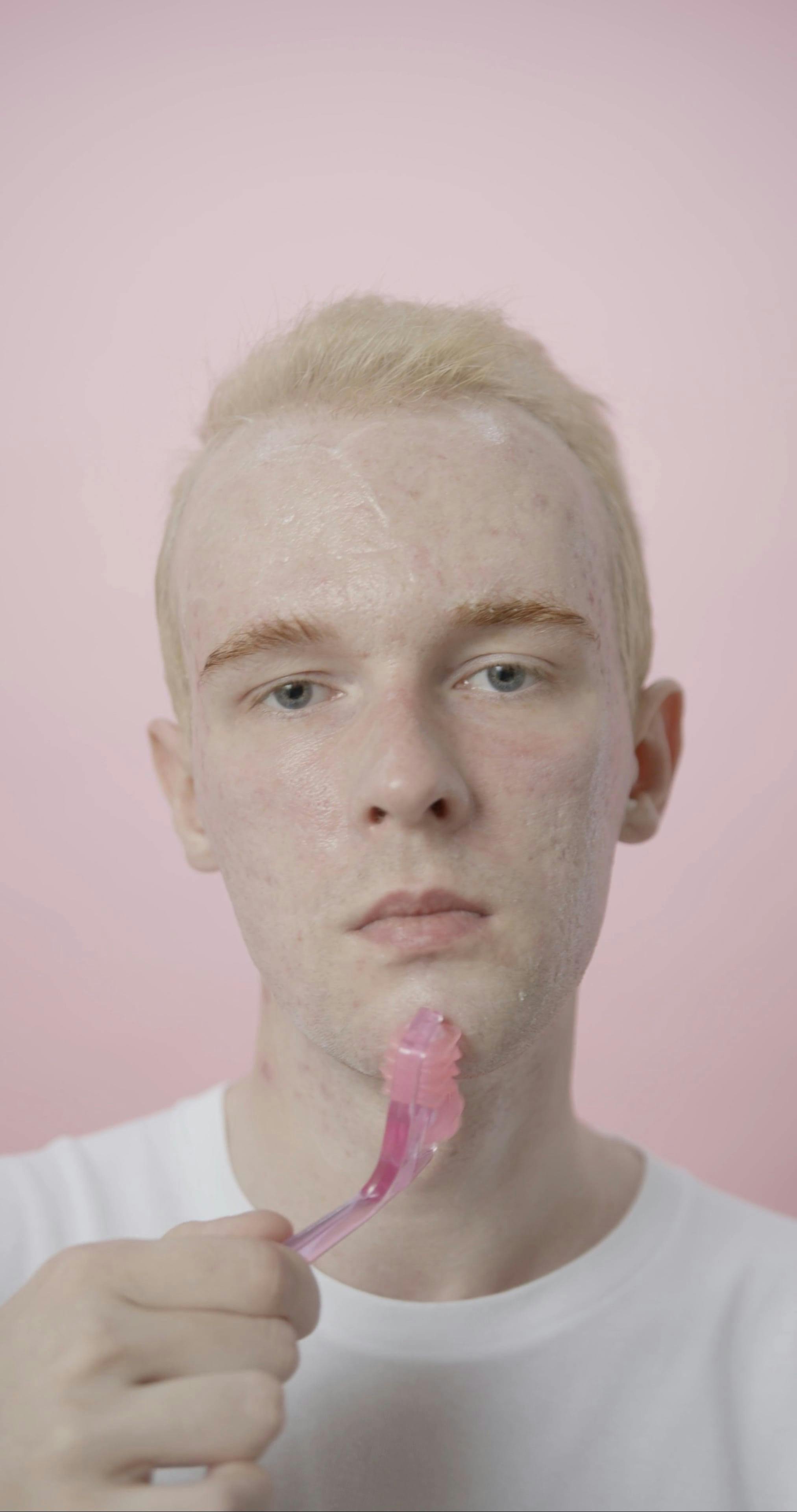A man with freckles is holding a pink brush Free Stock Video Footage ...