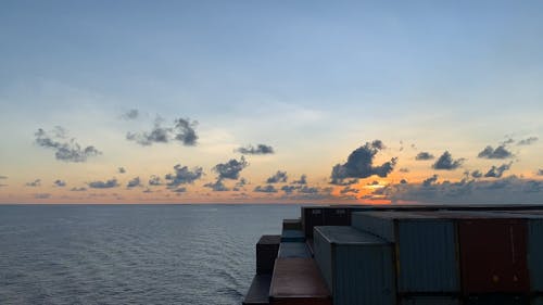 Cargo Ship In The Open Sea At Sunset