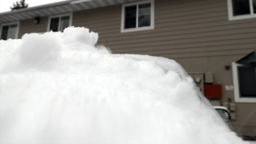 Person Removing Snow From His Car