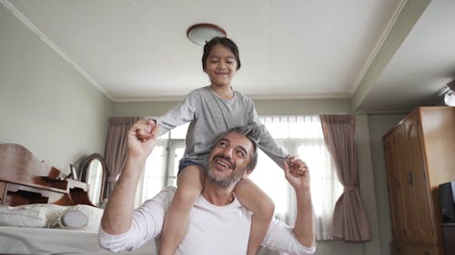 Father Carrying His Child on His Back While Having Fun