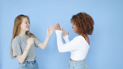 Two Women Having Fun Against Blue Background