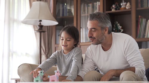 Dad and Daughter Playing With Animal Toys