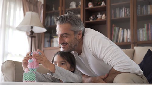 Dad and Daughter Playing With Animal Toys