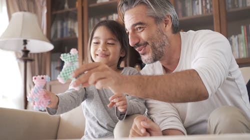 A Father Playing Toys With Her Daughter At Home