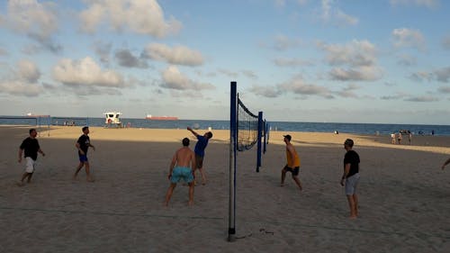Group of Men Playing Beach Volleyball