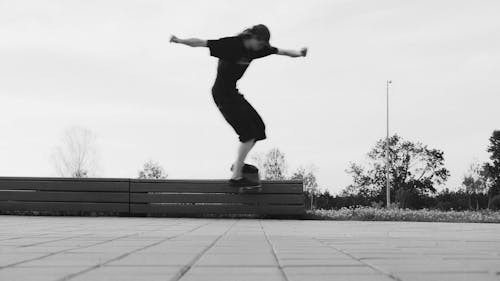 Two Young Men Doing A Boardslide Over A Railing