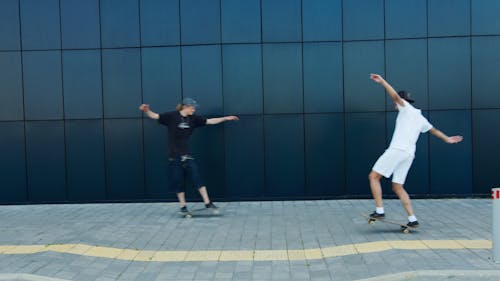 Two Young Men Doing Skateboard Tricks In Tandem