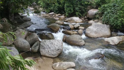 A River Water Flowing Through Boulder Of Rocks