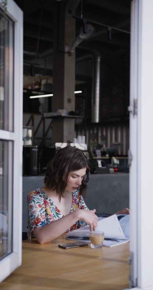 A Woman Looking At The Pages Of A Magazine